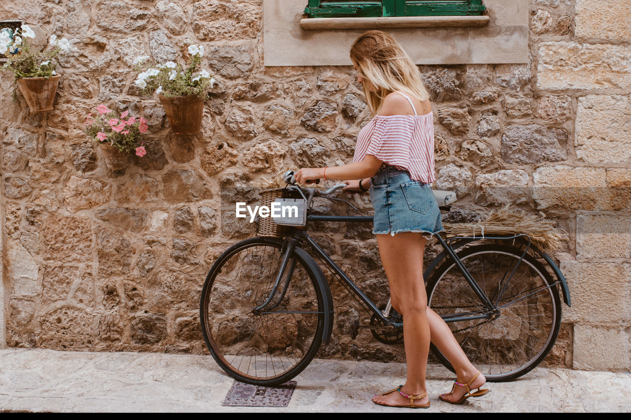 Blonde woman choosing the bike like transport in majorca