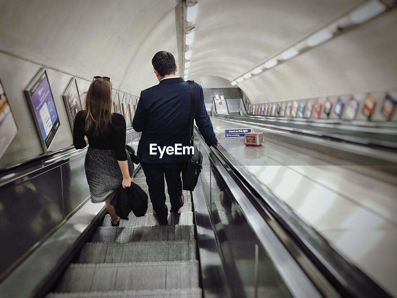 Rear view of people standing on escalator