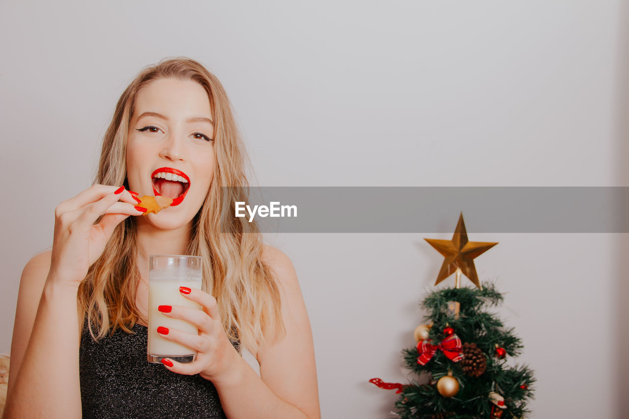 Portrait of young woman with christmas tree