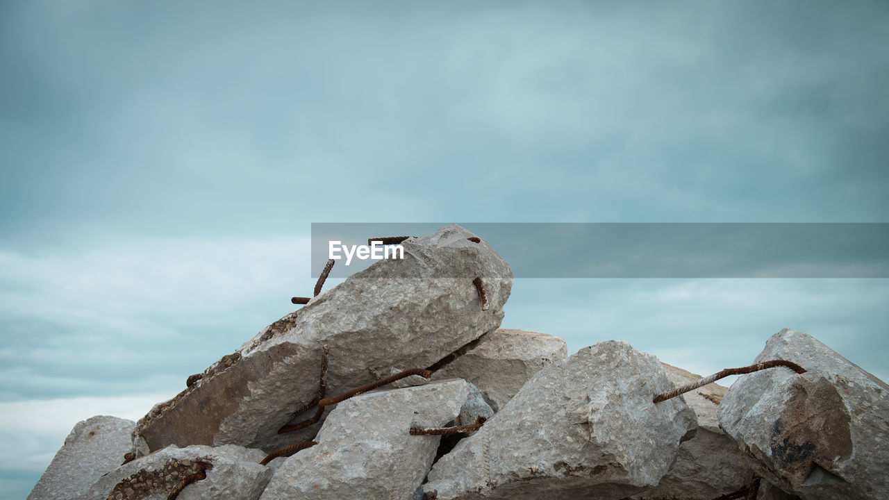 LOW ANGLE VIEW OF BIRDS PERCHING ON ROCK