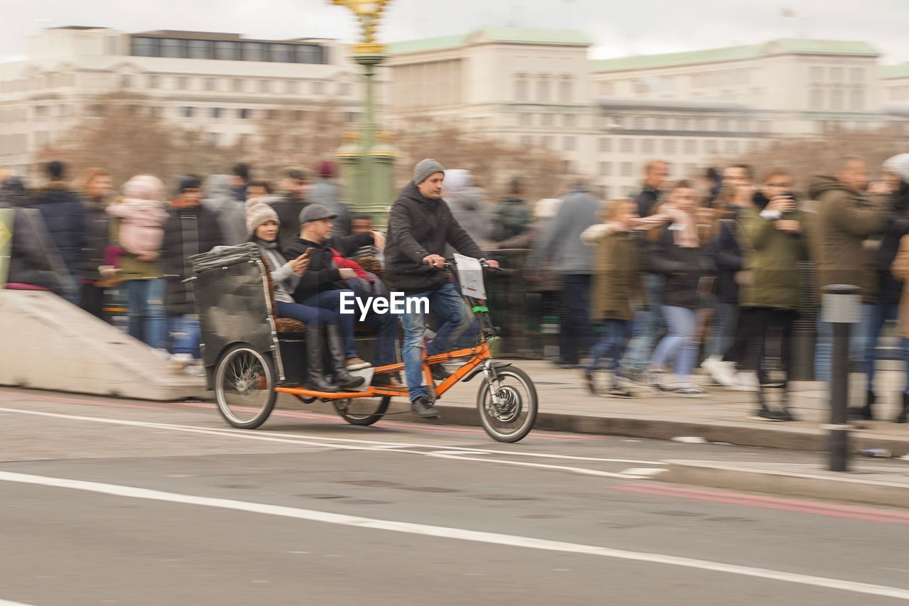PEOPLE RIDING BICYCLE ON CITY STREET