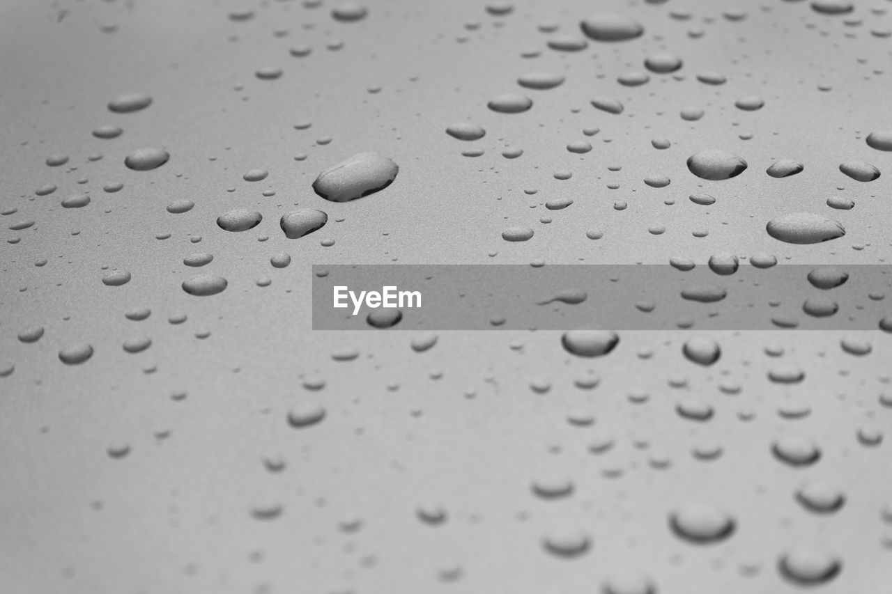 CLOSE-UP OF RAINDROPS ON GLASS WINDOW