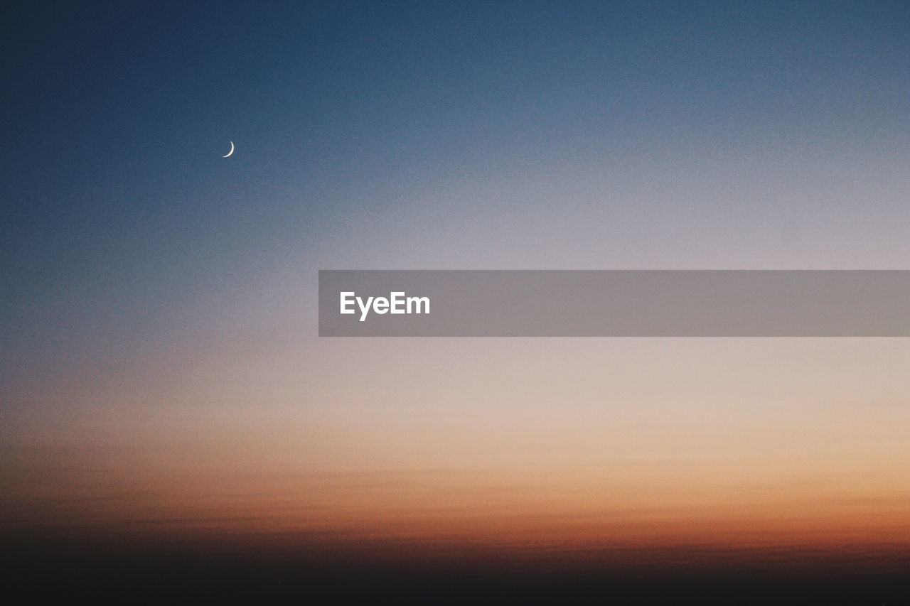 Low angle view of silhouette moon against sky at sunset