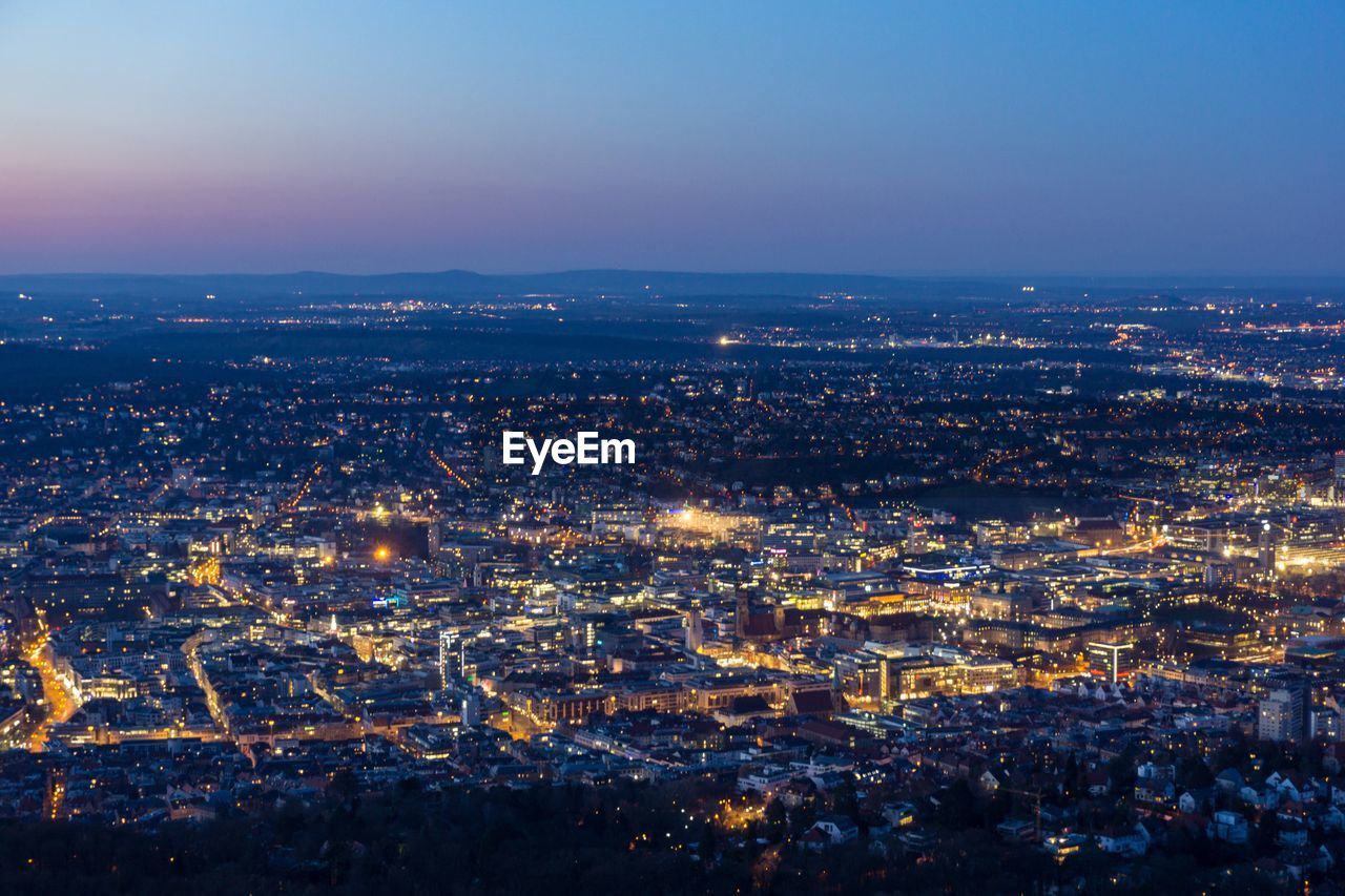 High angle view of illuminated cityscape against sky at dusk