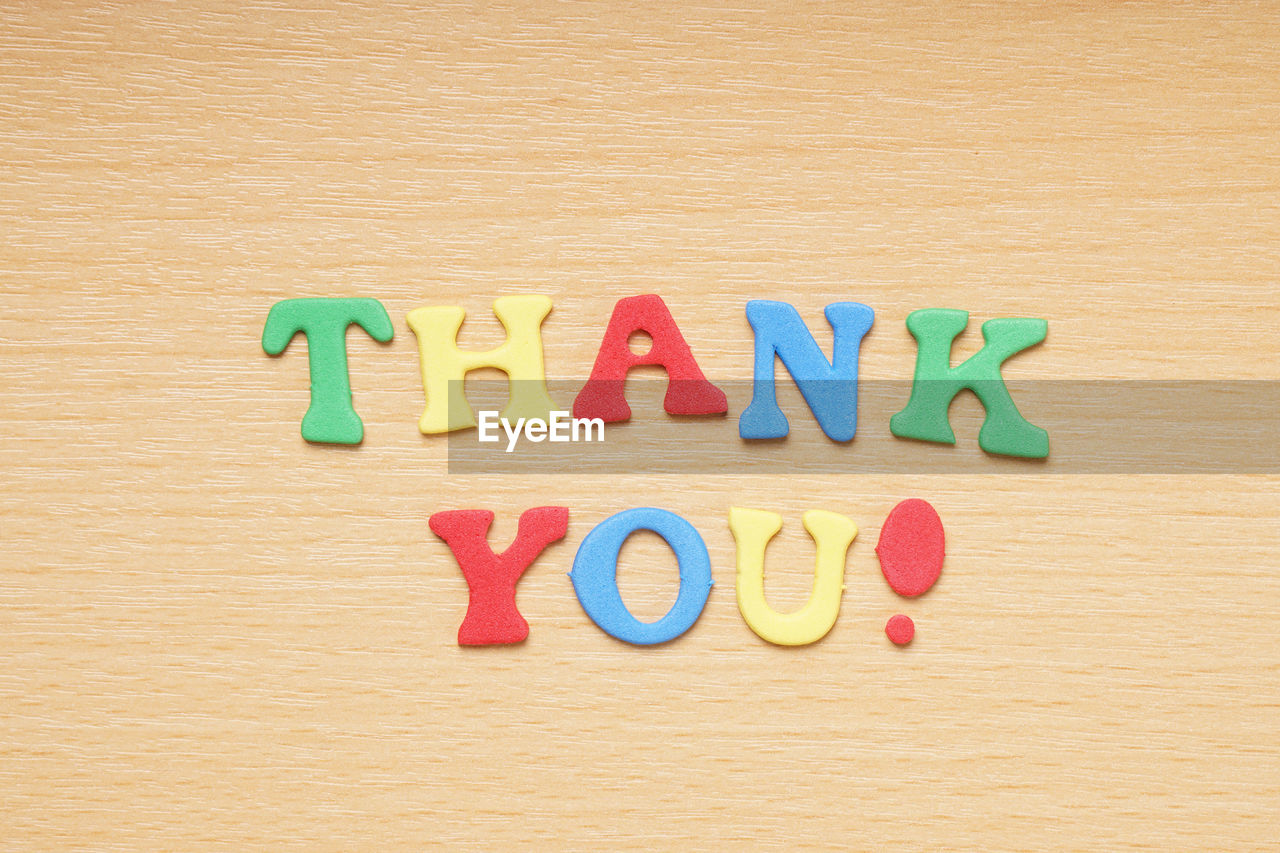 Directly above view of thank you foam text on table