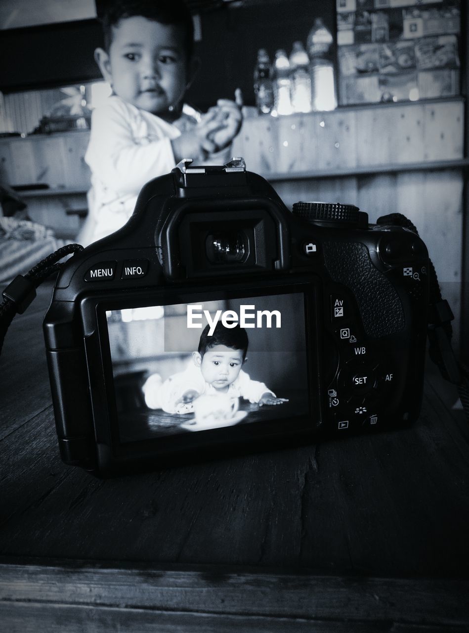 Close-up of camera photographing baby boy at supermarket