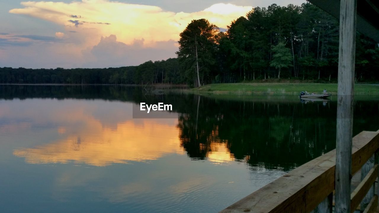 SCENIC VIEW OF CALM LAKE AT SUNSET