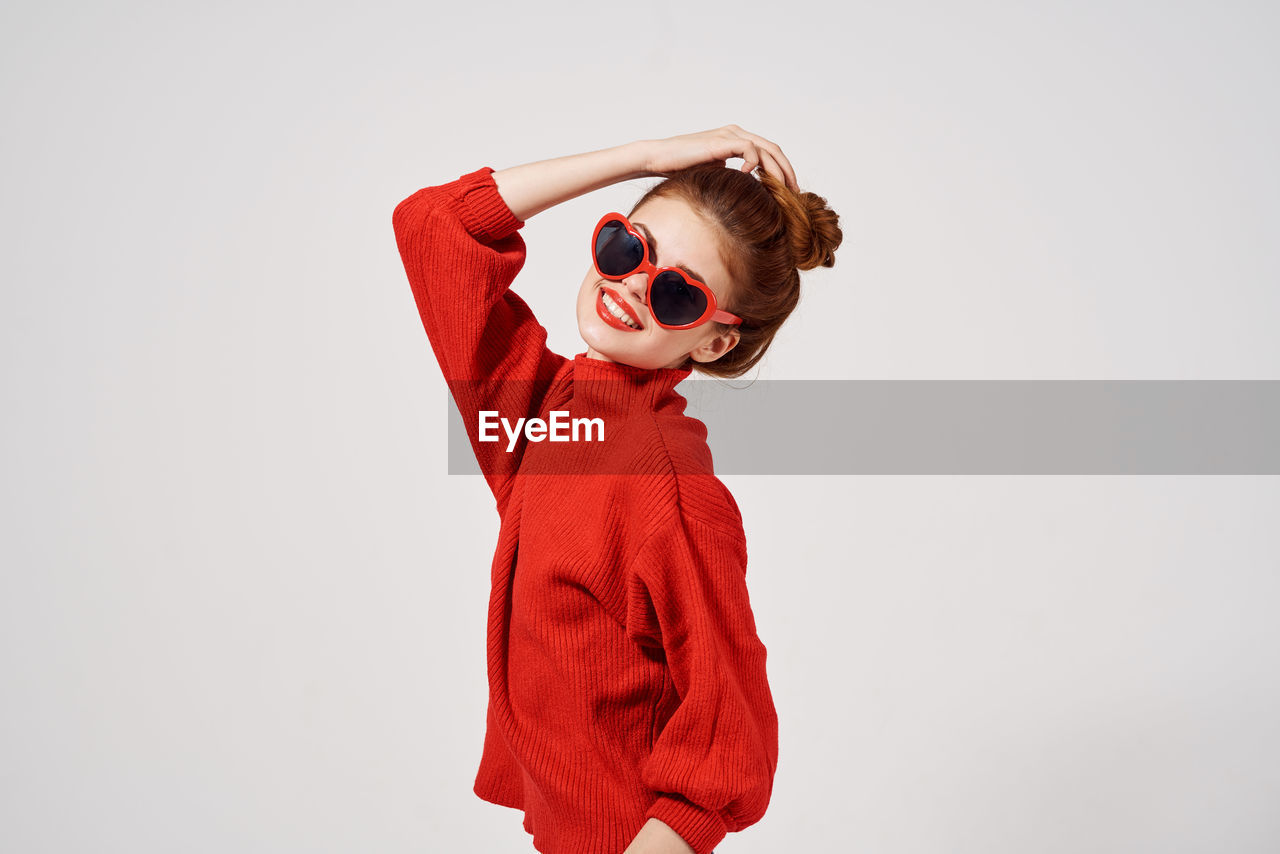 Boy standing against red background