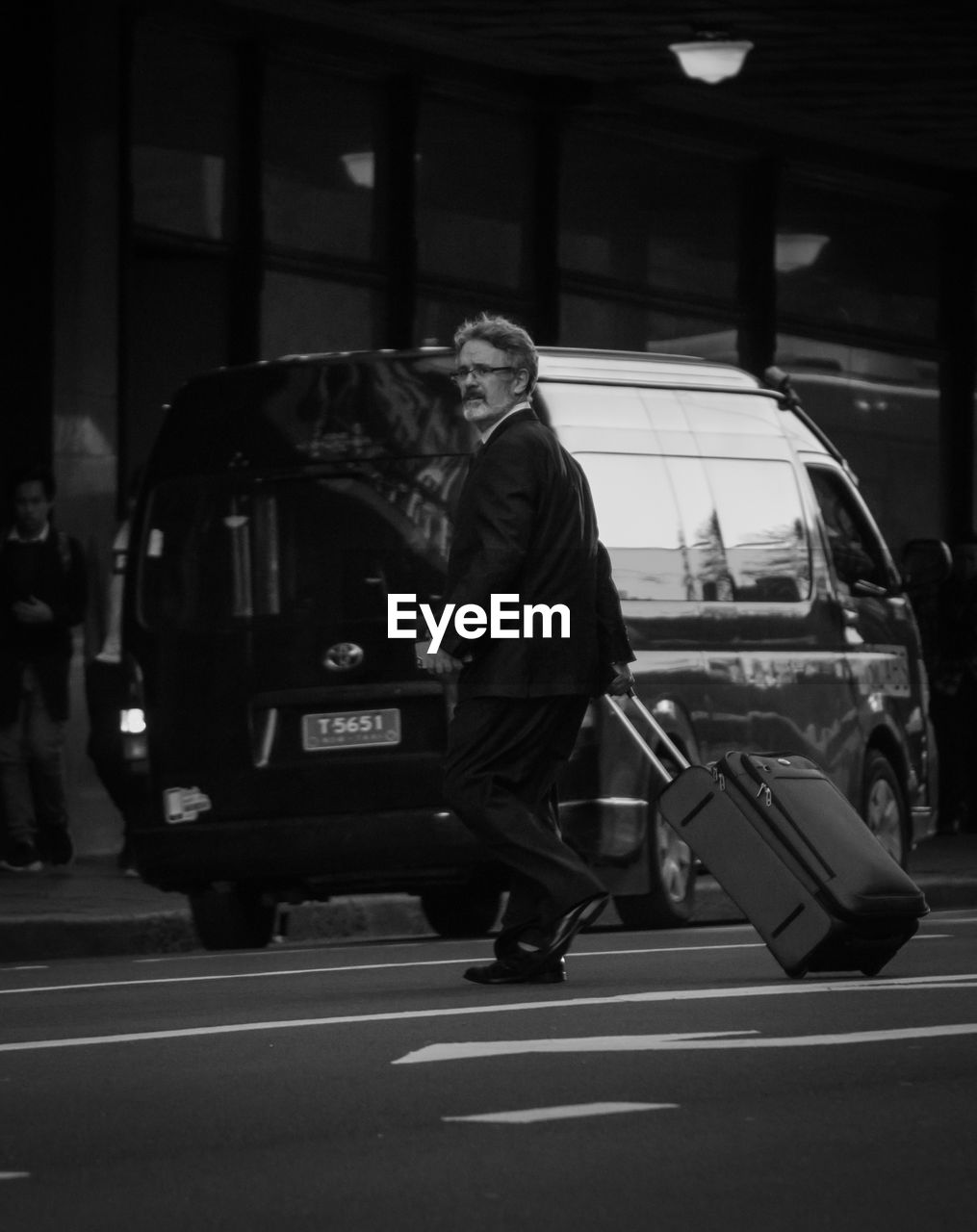 MAN WITH UMBRELLA WALKING ON STREET