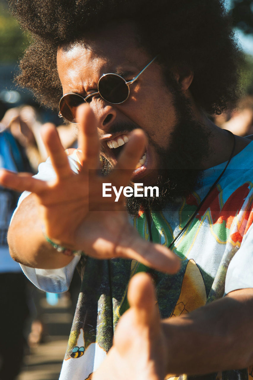 Portrait of mid adult man wearing sunglasses while screaming outdoors