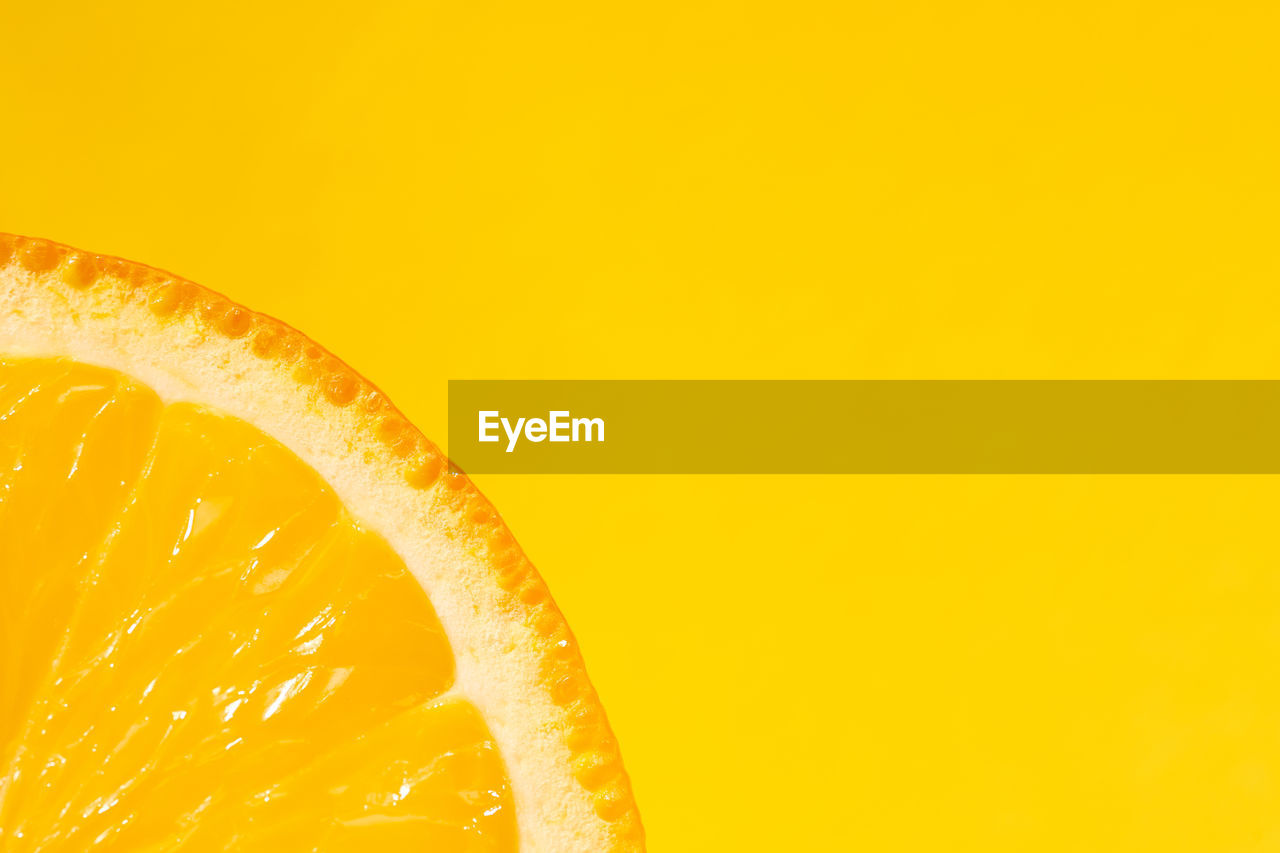 Sliced orange, yellow background, copy space. fresh juicy fruit, source of vitamin c. bright