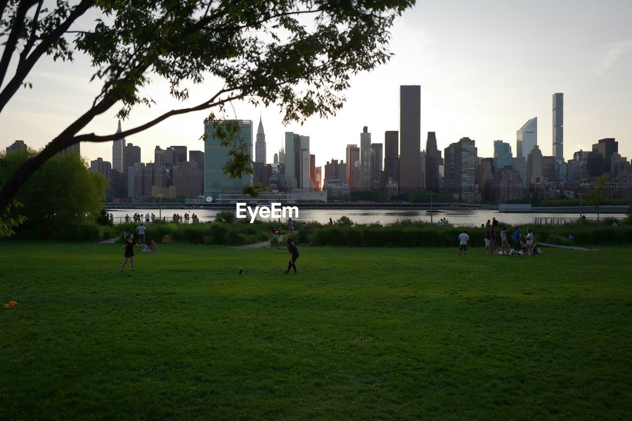 People in park by city against sky