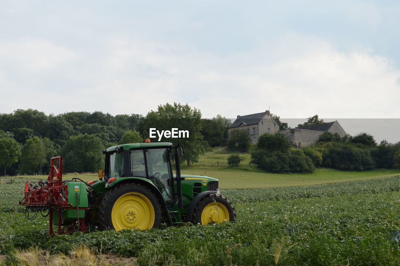 Tractor on agricultural field against sky