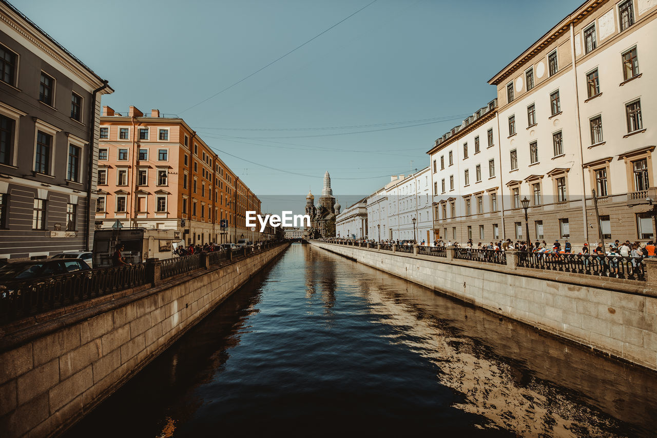 Canal amidst buildings against sky in city