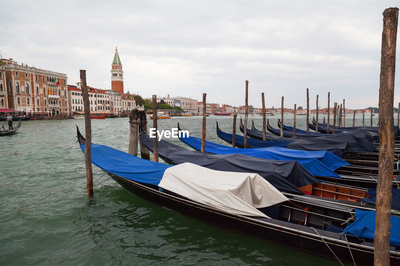 Gondola moored in grand canal against buildings and sky