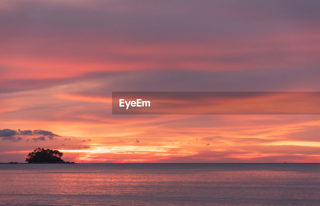 Scenic view of sea against romantic sky at sunset with a small island