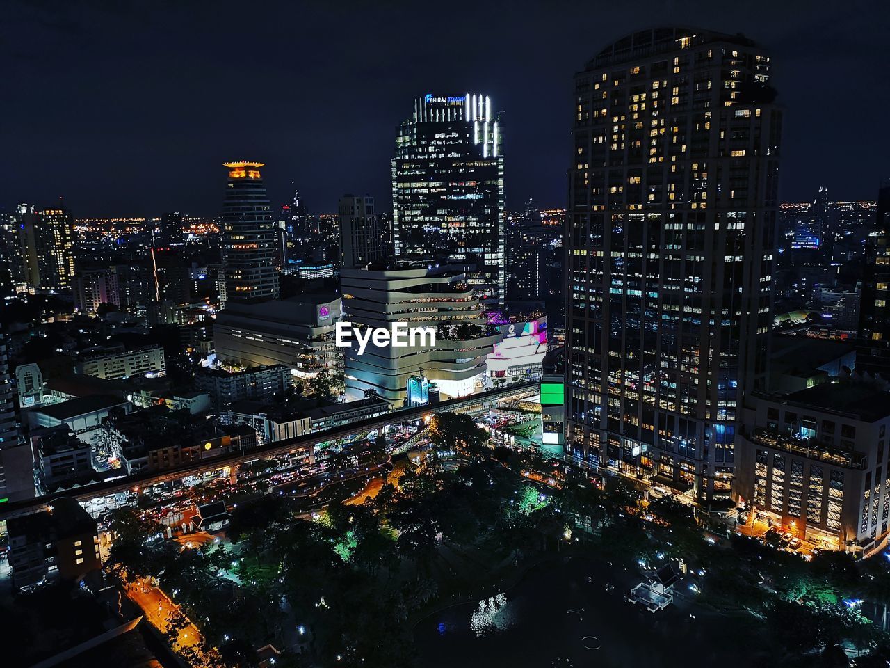 HIGH ANGLE VIEW OF ILLUMINATED CITY BUILDINGS AT NIGHT