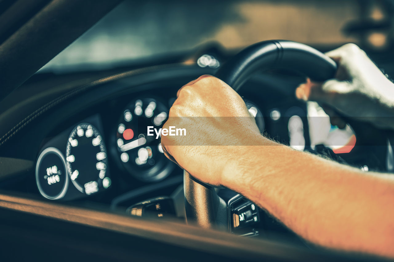 Close-up of hand holding steering wheel