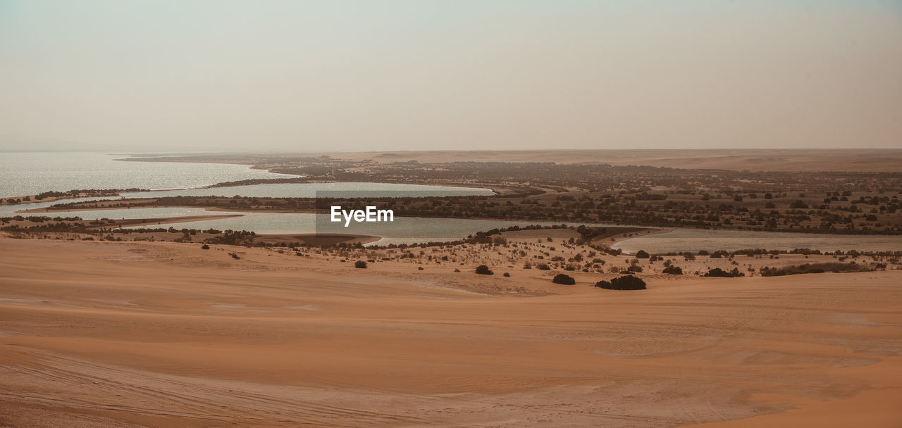 SCENIC VIEW OF SAND DUNES AGAINST CLEAR SKY