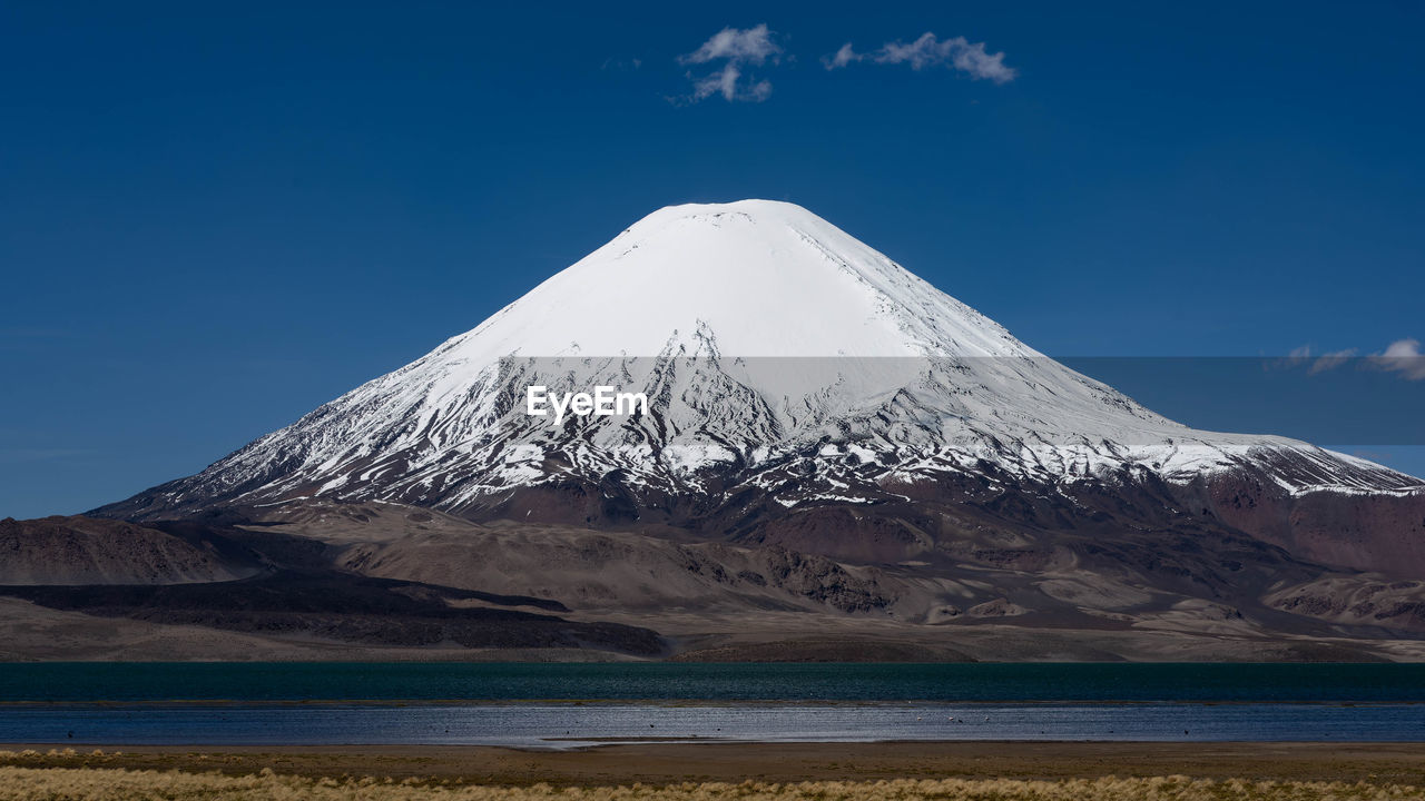 mountain, landscape, volcano, snow, environment, scenics - nature, sky, beauty in nature, stratovolcano, cold temperature, snowcapped mountain, nature, travel destinations, winter, land, plateau, no people, water, travel, non-urban scene, geology, mountain peak, volcanic landscape, blue, tranquil scene, tranquility, natural environment, outdoors, cloud, tourism, day, wilderness, cinder cone, mountain range, lake, plain, horizon