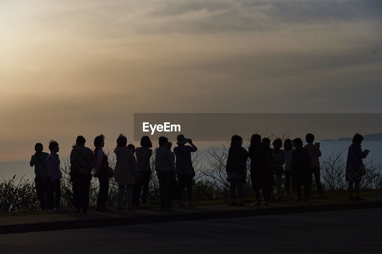 Silhouette women standing against sky during sunset