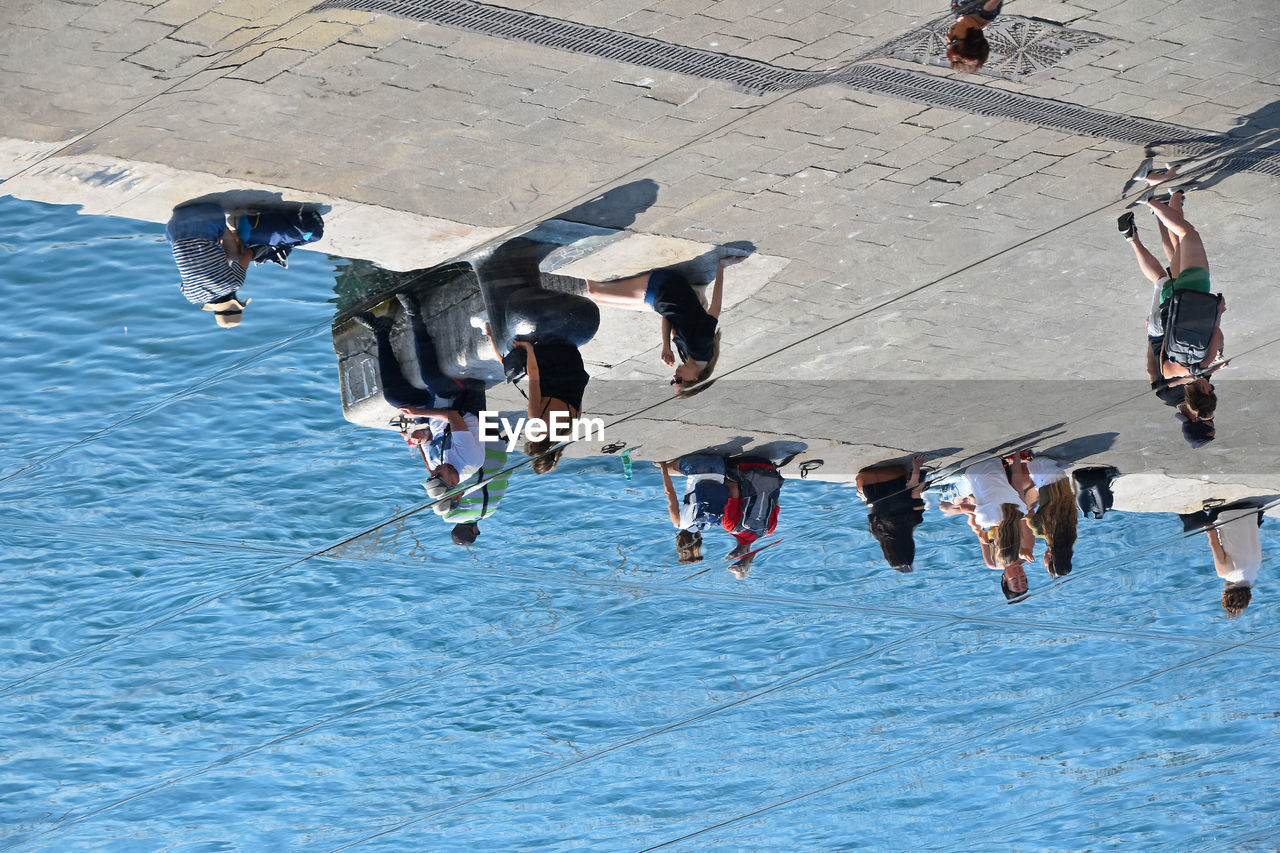 High angle view of people sitting on promenade in city