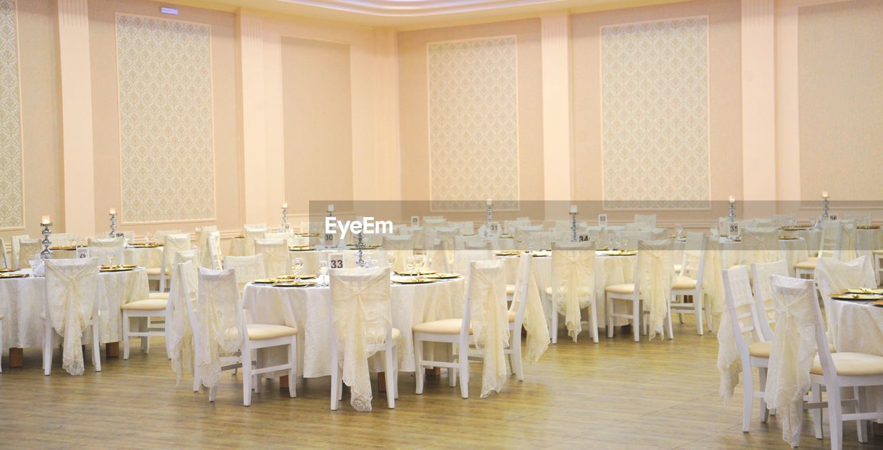 function hall, seat, chair, ballroom, banquet, meal, table, indoors, room, furniture, no people, conference hall, event, absence, empty, architecture, interior design, aisle, business, large group of objects, in a row, building