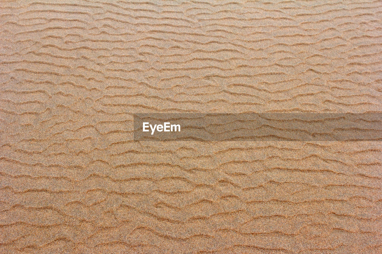 HIGH ANGLE VIEW OF SAND ON BEACH
