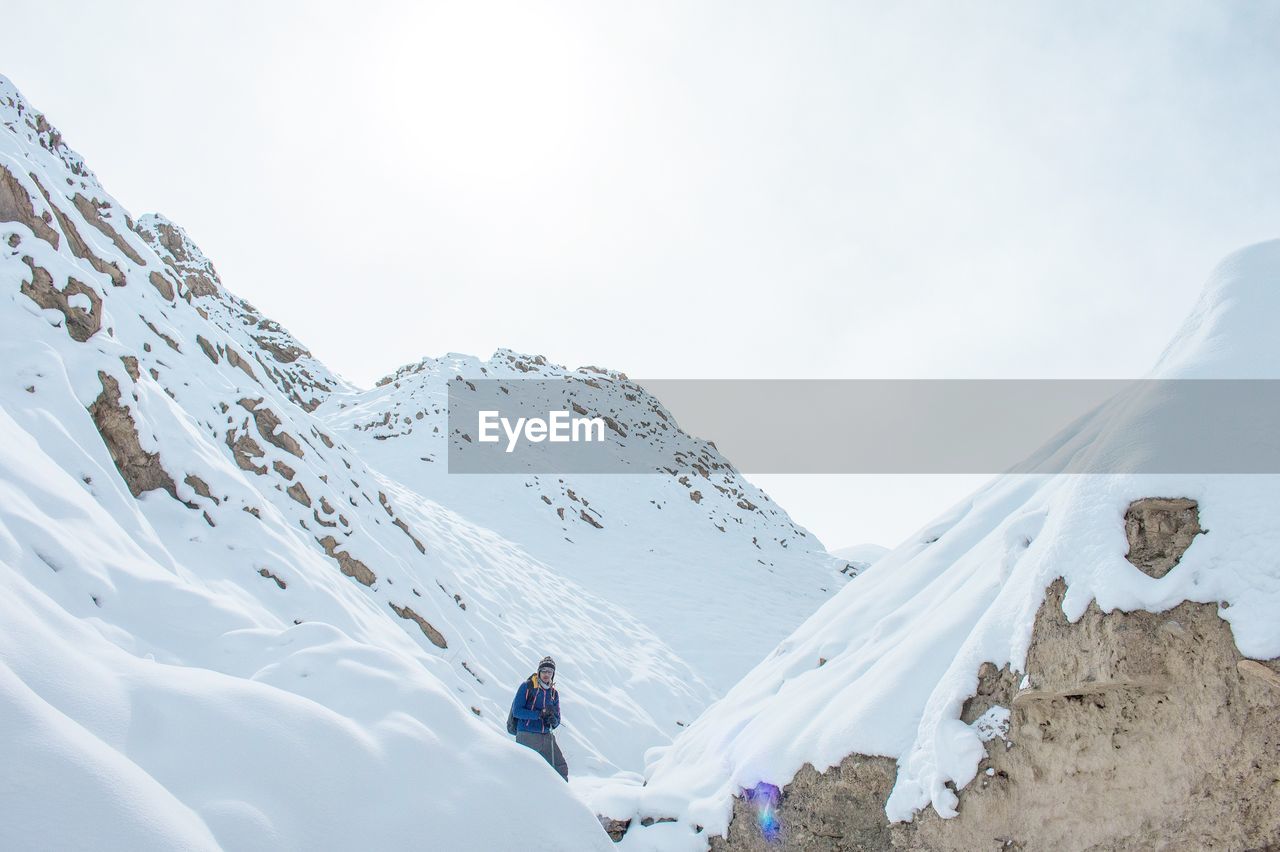 Man on snowcapped mountain against sky