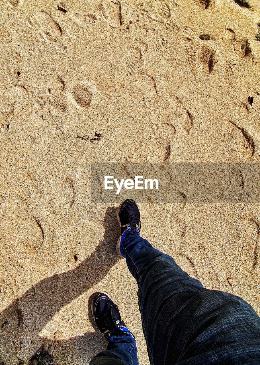 LOW SECTION OF MAN STANDING ON SHORE