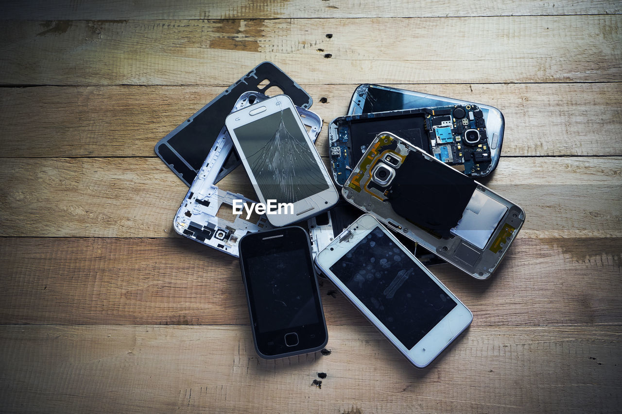 High angle view of damaged smart phones on table