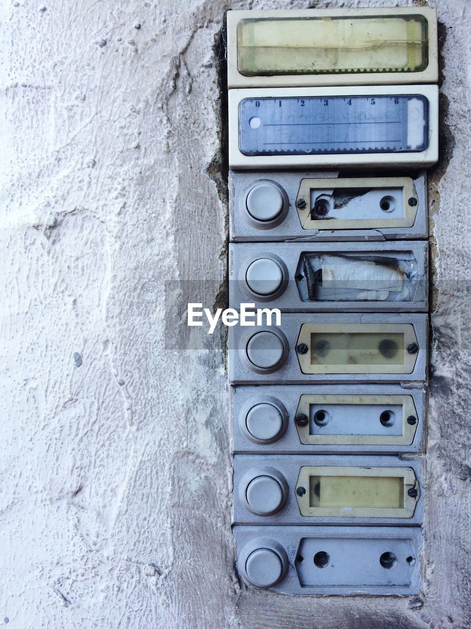 Close-up of old bell nameplate on wall