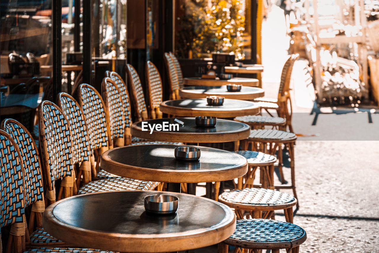 EMPTY CHAIRS AND TABLES IN CAFE