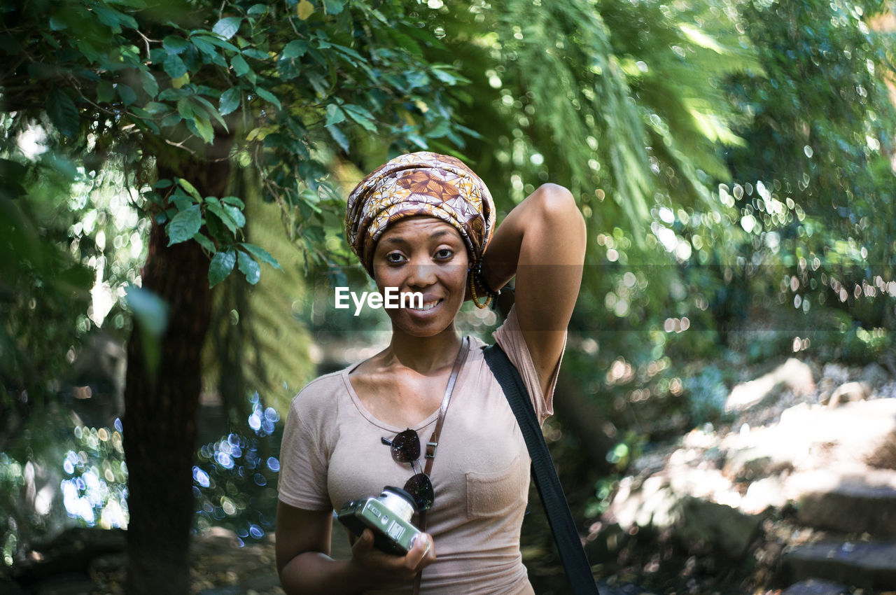 Portrait of smiling mid adult woman standing in forest