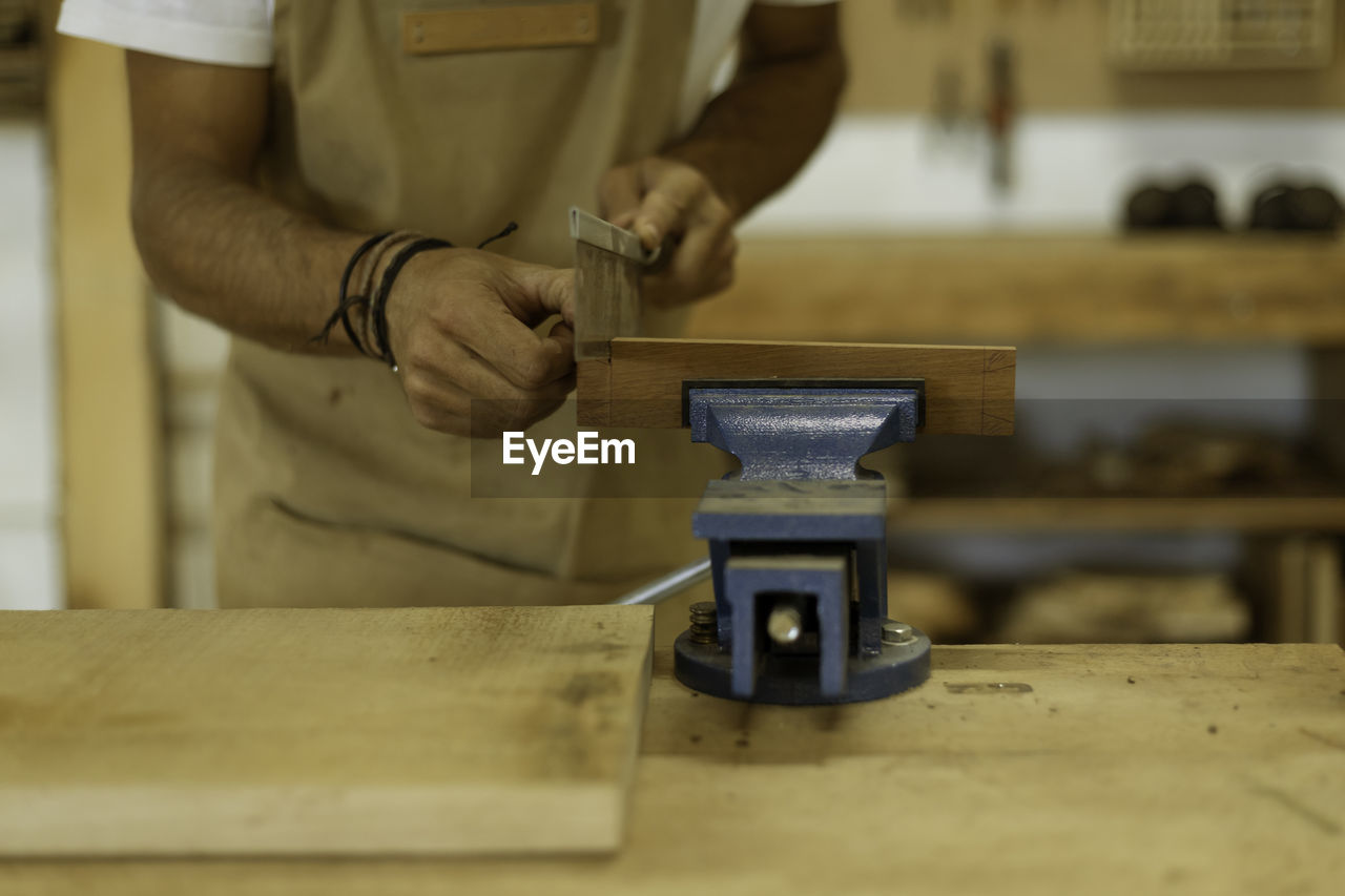 Midsection of carpenter working at workshop