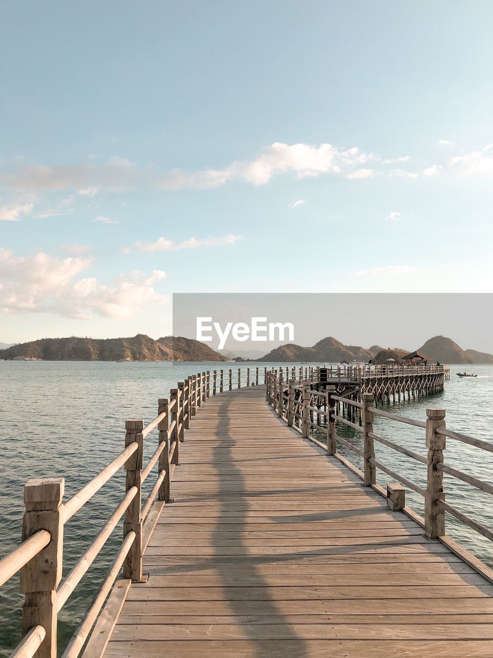 Wooden pier over sea against sky