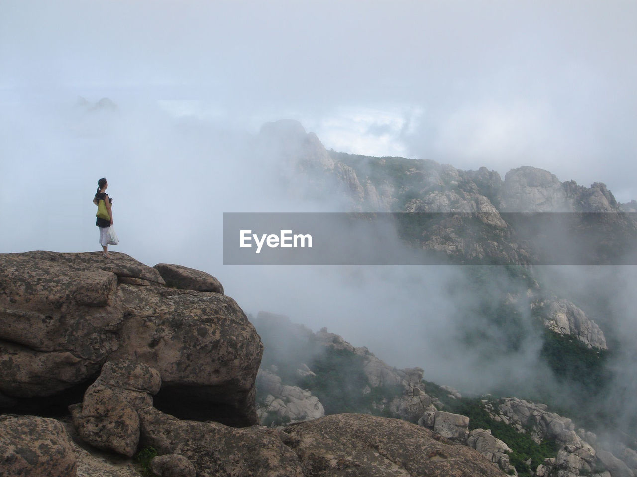 Woman standing on rocky mountain