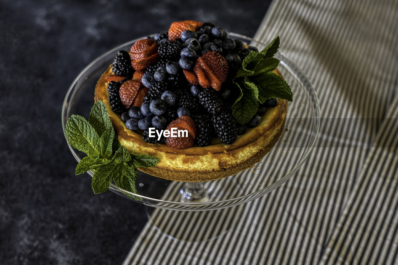 Cheesecake and berries with mint leaves