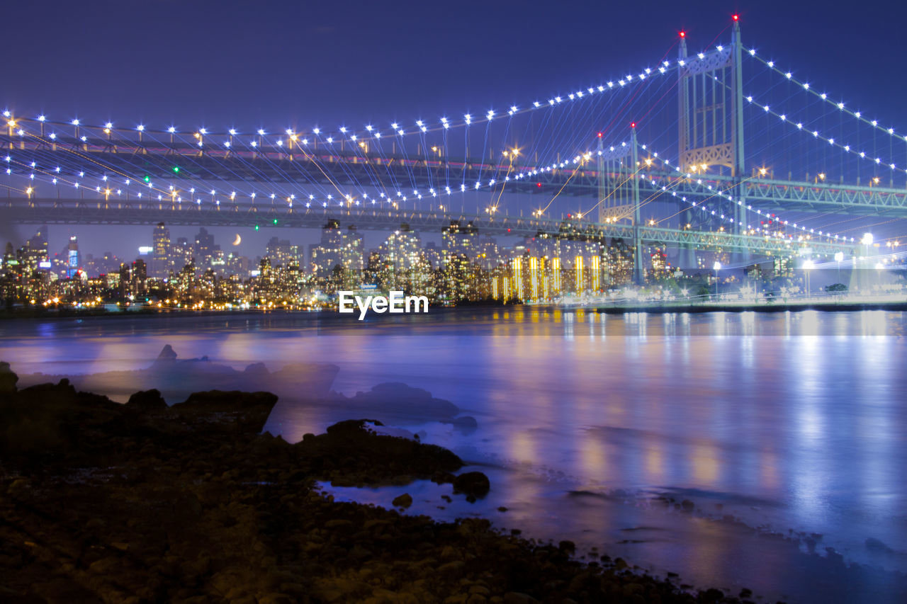 Illuminated queensboro bridge of east river against clear sky at night