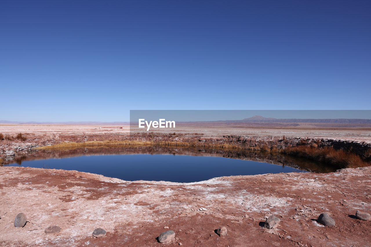 sky, landscape, natural environment, water, scenics - nature, environment, nature, lake, blue, clear sky, beauty in nature, land, tranquility, desert, no people, tranquil scene, shore, wilderness, travel destinations, travel, day, non-urban scene, copy space, arid climate, outdoors, plateau, sunny, reflection, sand, tourism, climate, mountain, coast, mineral, semi-arid, salt flat, remote, rock, horizon, reservoir