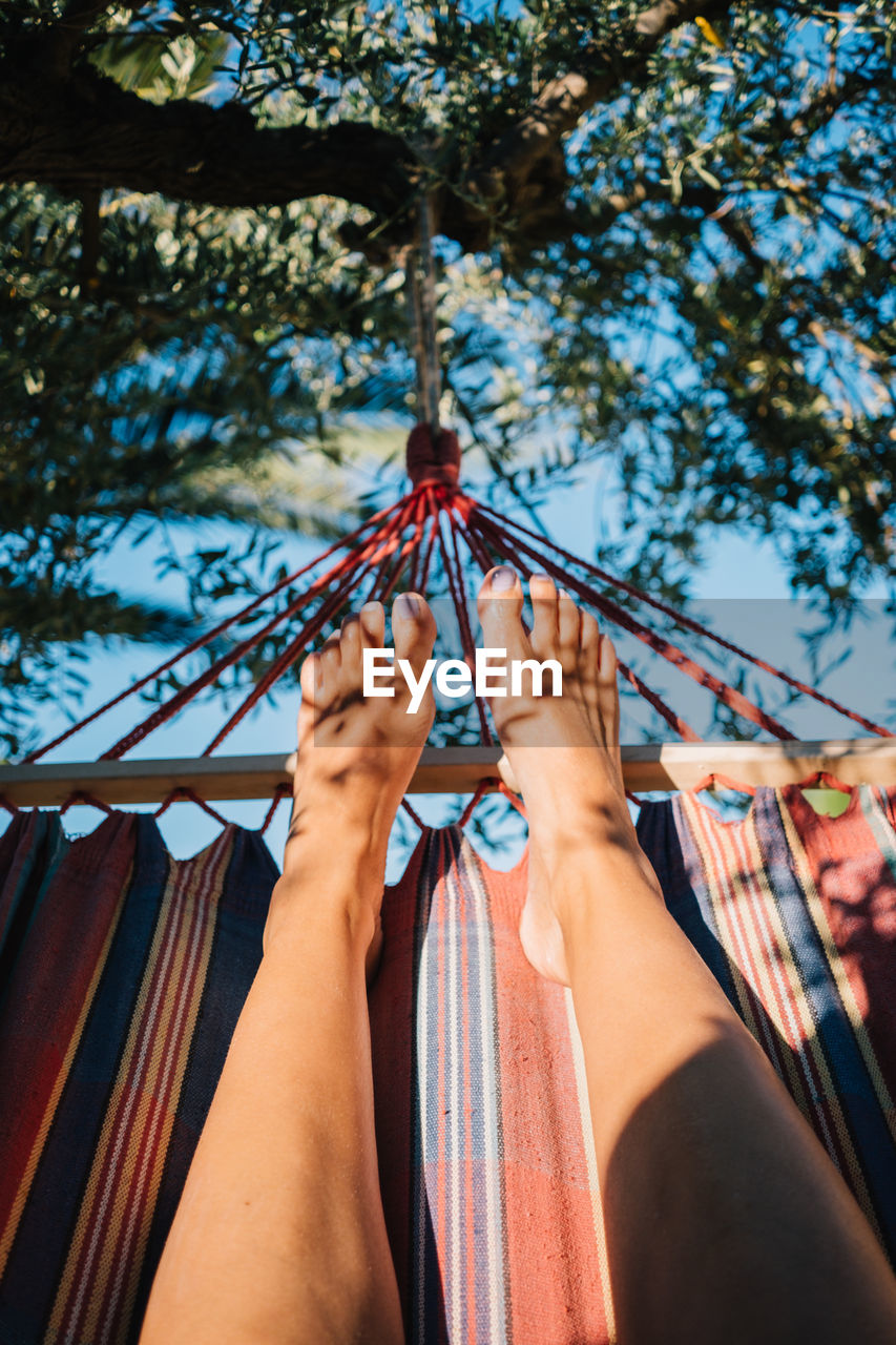 Low angle view of woman standing on hammock