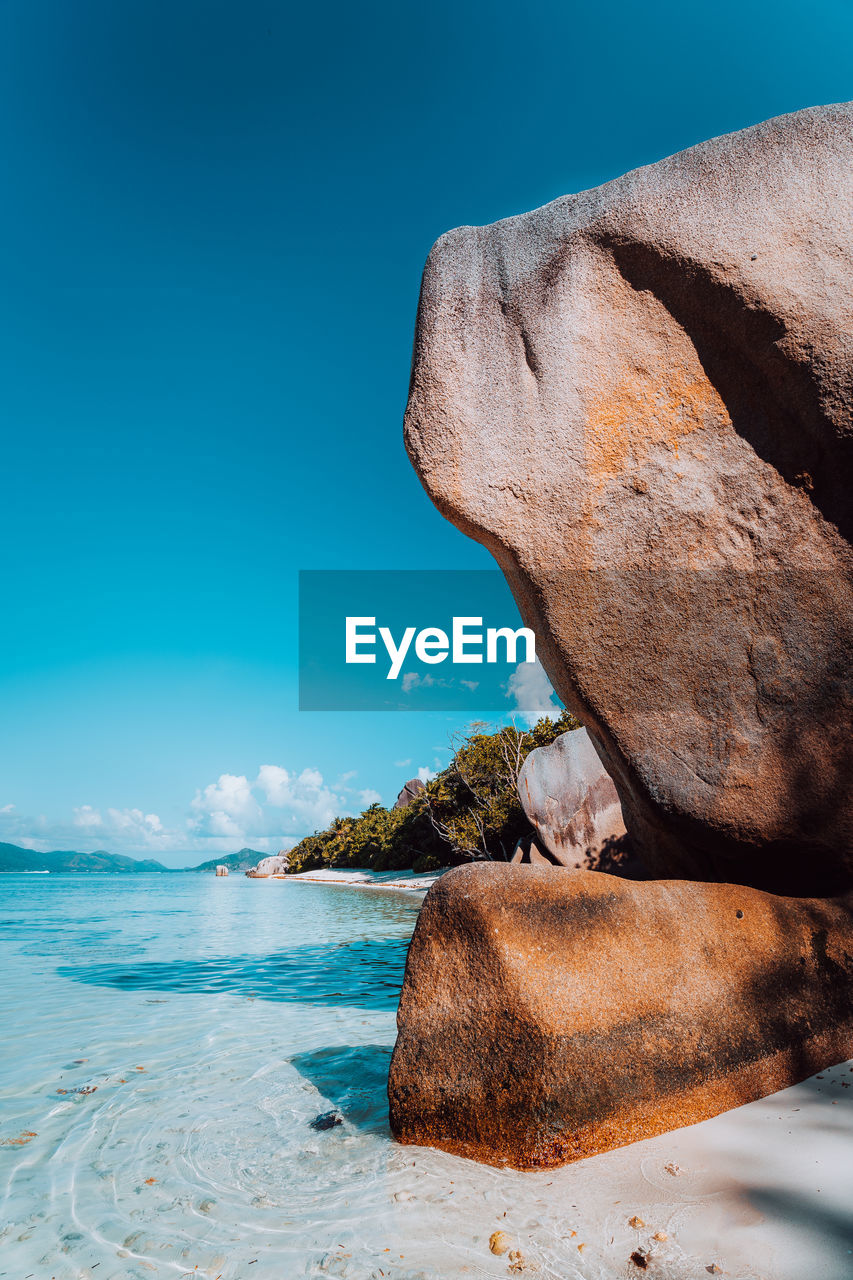 SCENIC VIEW OF SEA SHORE AGAINST BLUE SKY
