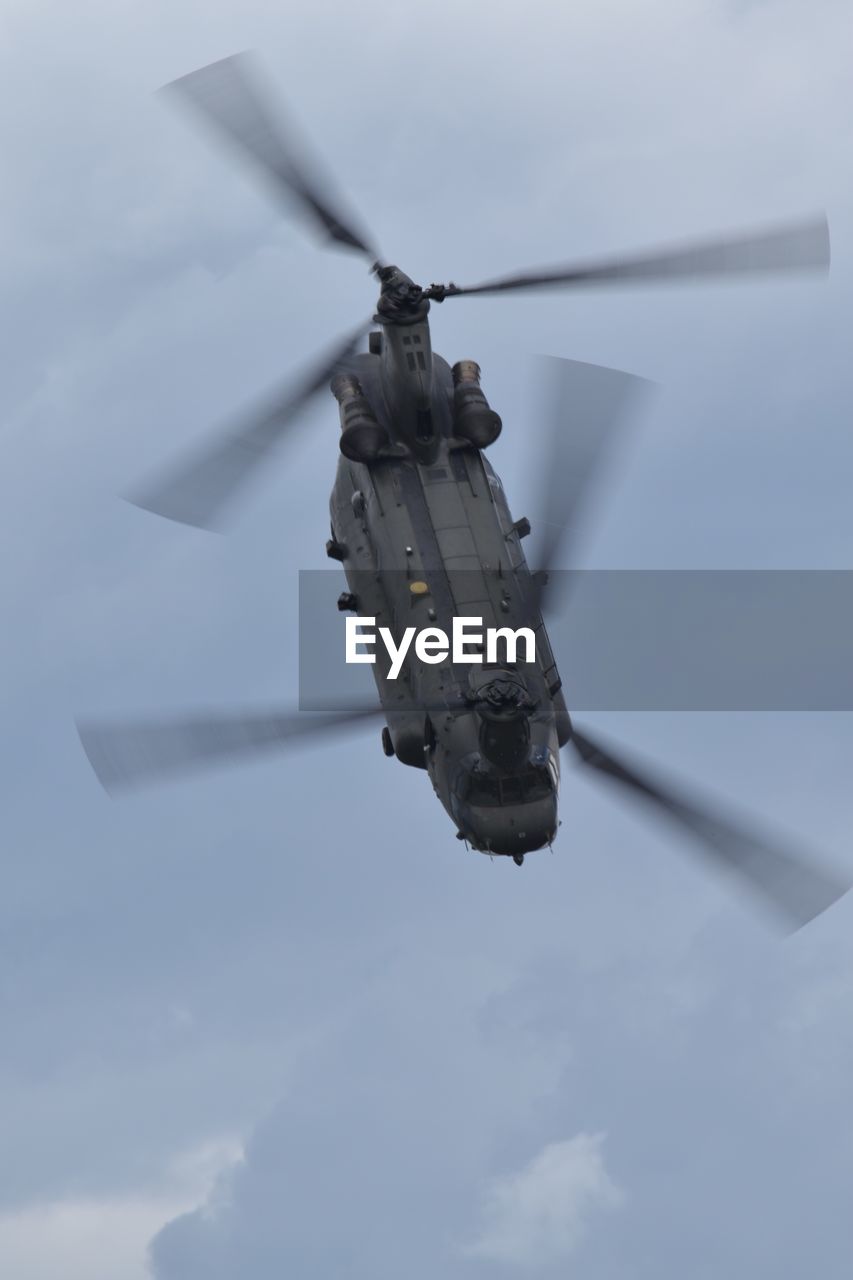 Low angle view of helicopter flying against sky