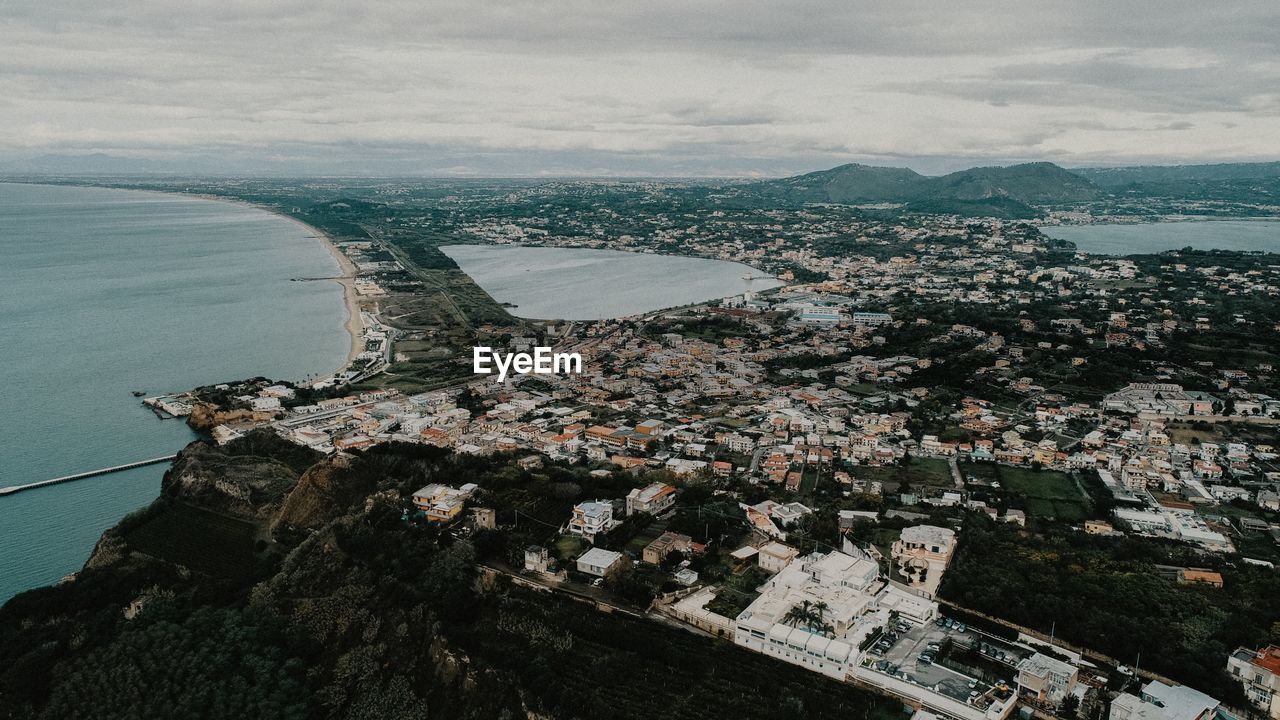 High angle view of buildings by sea against sky