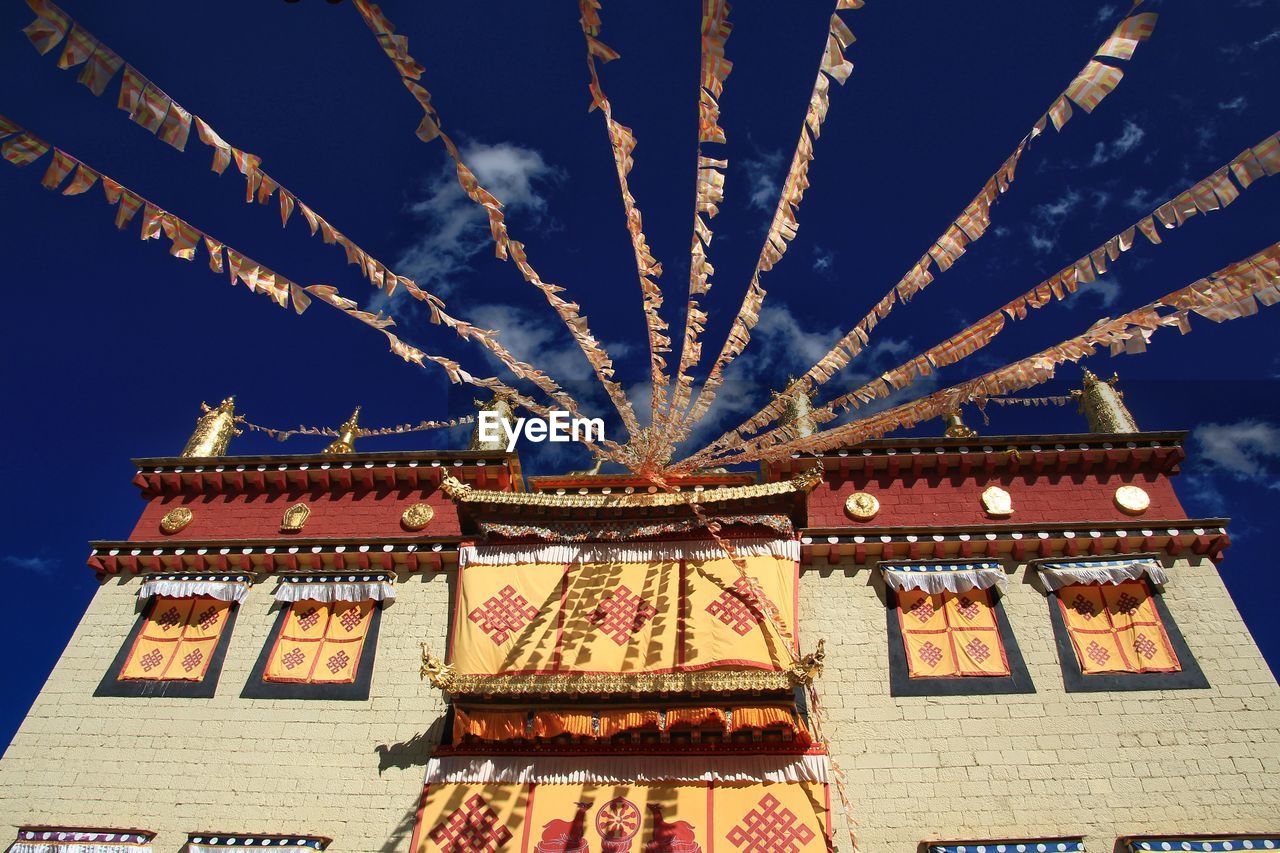 LOW ANGLE VIEW OF ILLUMINATED TRADITIONAL BUILDING AGAINST SKY