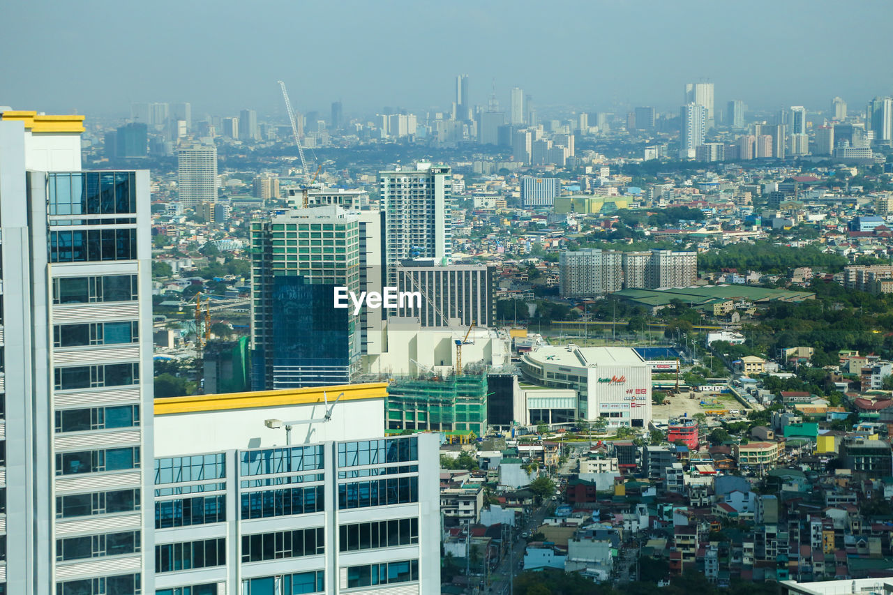 HIGH ANGLE VIEW OF BUILDINGS AGAINST SKY IN CITY