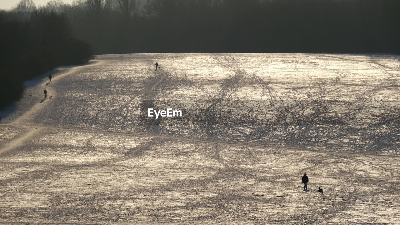 High angle view of people walking on snowy field