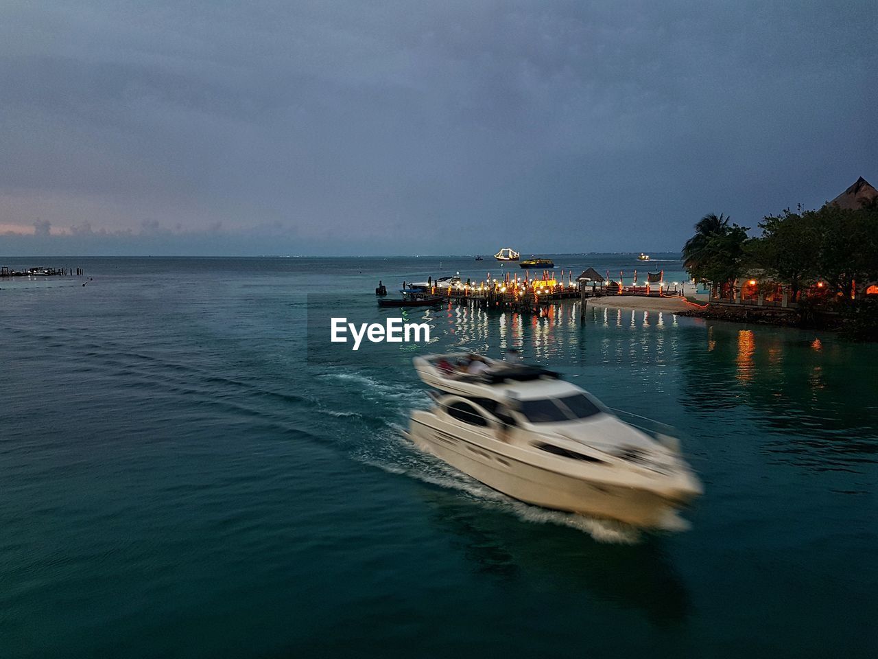 Boat sailing in sea against sky at night