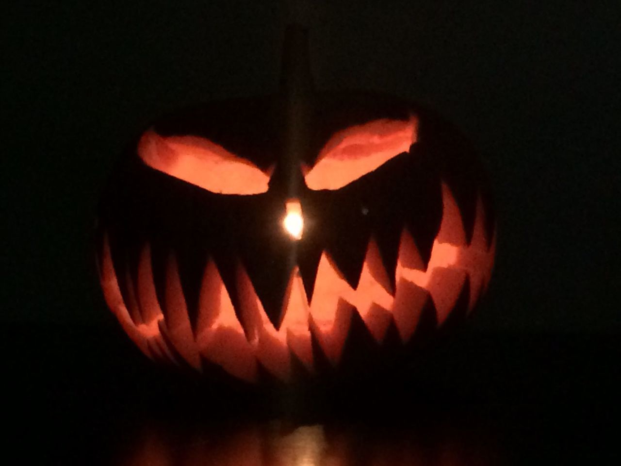 CLOSE-UP OF ILLUMINATED PUMPKIN AGAINST BLACK BACKGROUND AT NIGHT