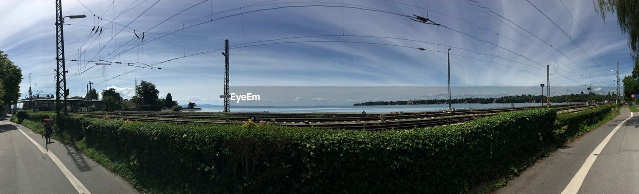 PANORAMIC SHOT OF ROAD BY PLANTS AGAINST SKY